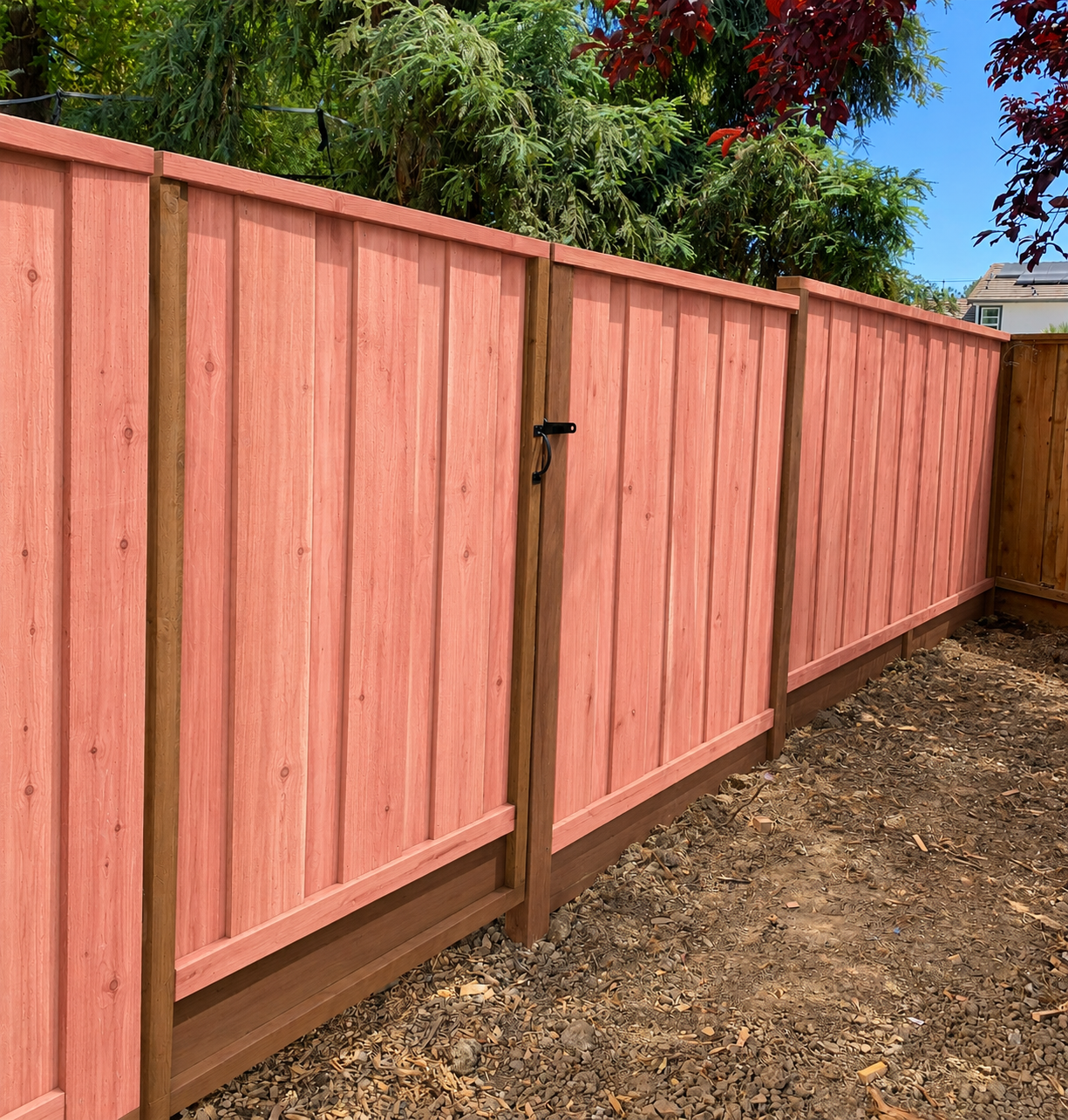 Fresh redwood privacy fence with matching side gate and framed wood construction.