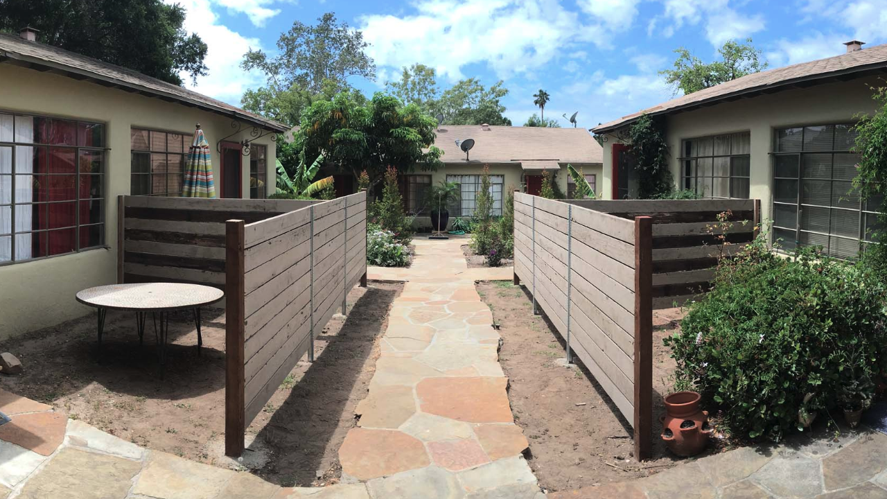 Horizontal wood courtyard privacy fence with stained posts and clean residential walkway layout.