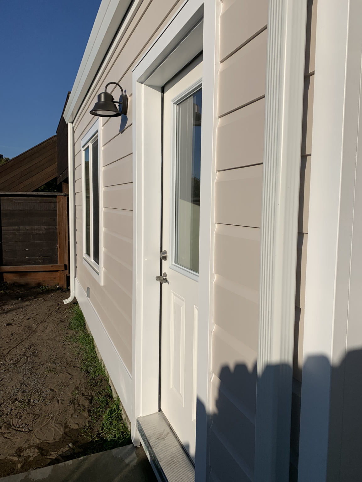 Residential home addition exterior with siding, windows, exterior door, and trim work.